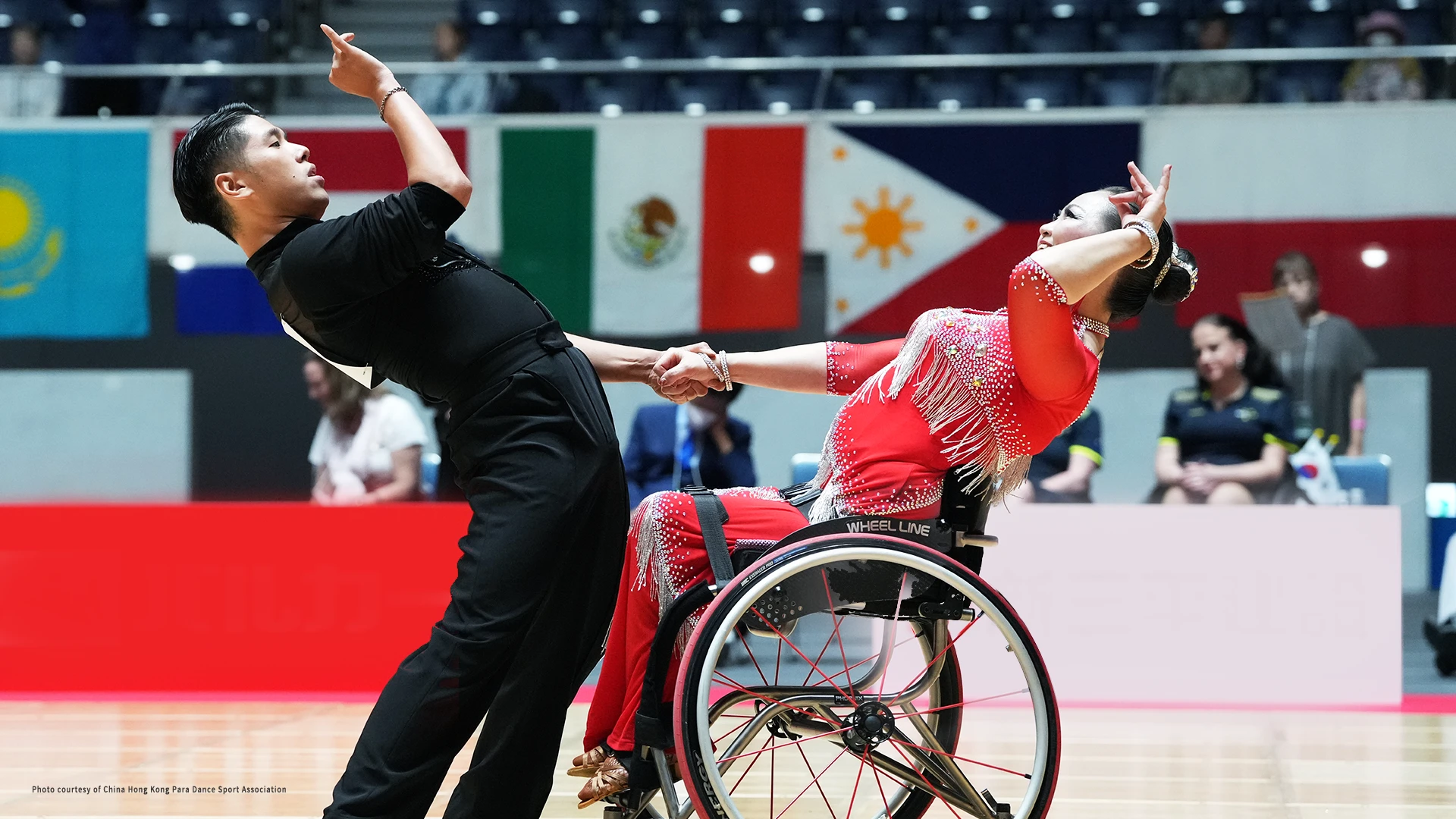 A man and a woman in wheelchairs competing together in the Para Dance Sport event.